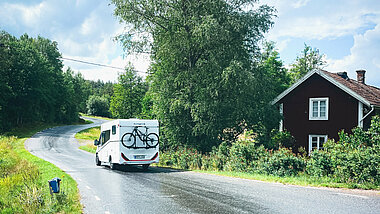Camper van passes Swedish house