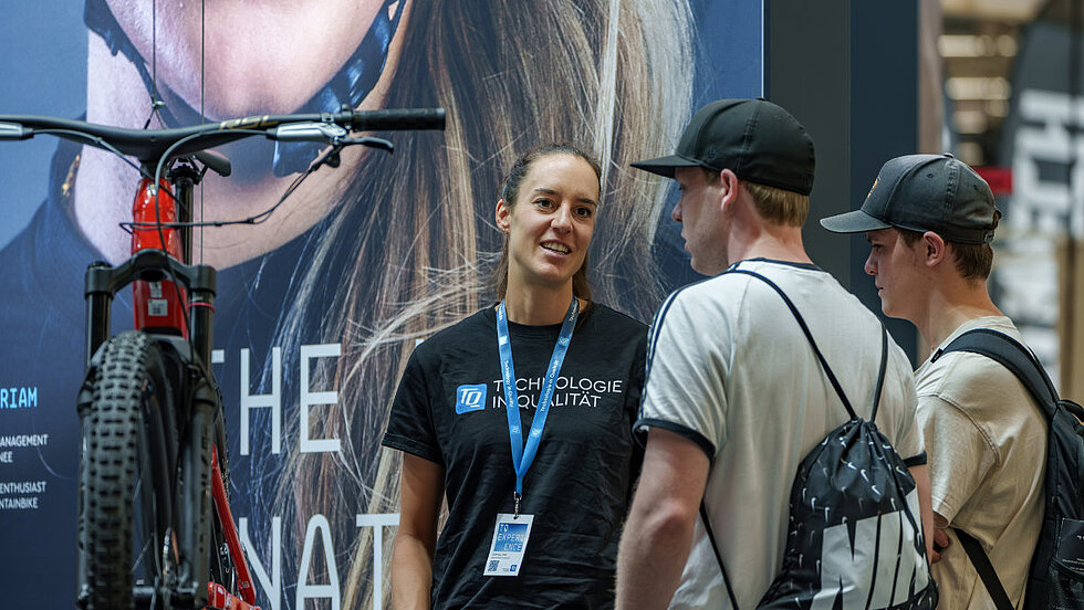 TQ employee in conversation at the trade fair stand