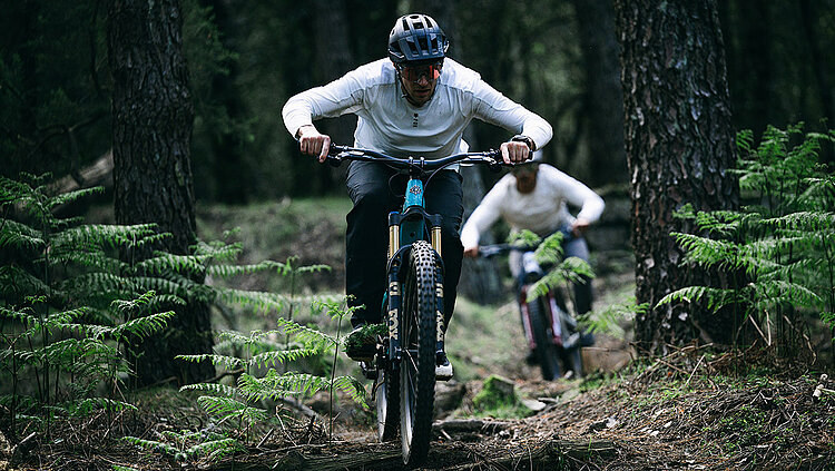 Mountainbiker im Wald Frontansicht