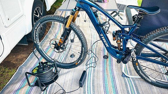 E-Bike lädt an der Steckdose vom Camper
