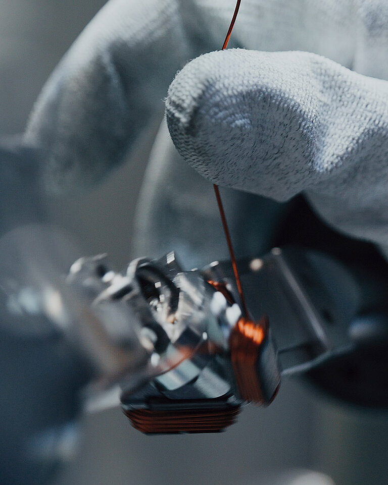 Hand mit Kupferdraht in der Produktion
