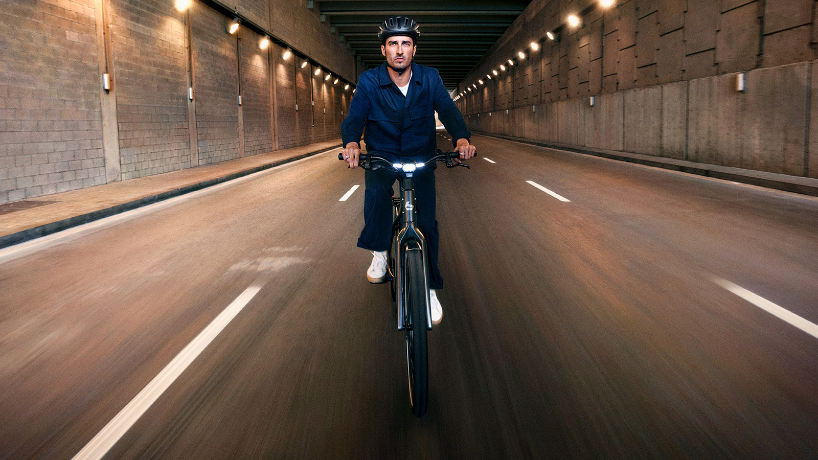 Front view Man riding e-bike in tunnel