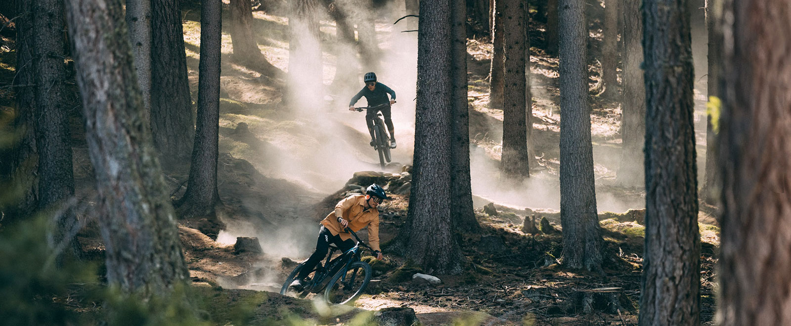 Two bikers with Trek Fuel EXe E-Bike riding a trail in forest